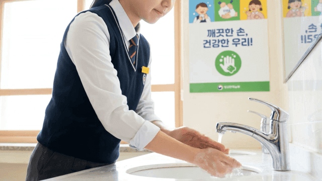 학교 화장실에서 손을 씻는 여학생