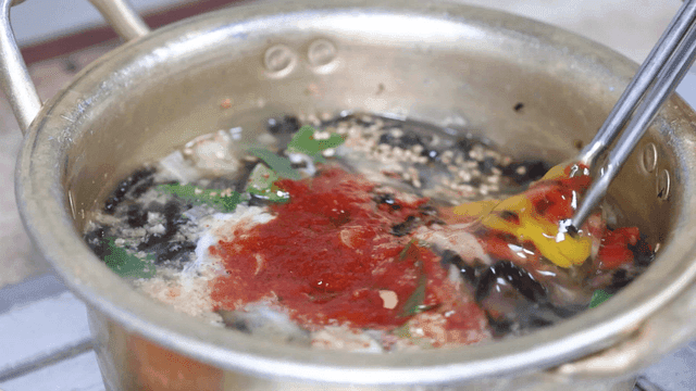 젓가락으로 섞이는 계란 닭칼국수