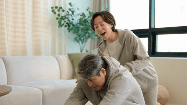 거실에서 스트레칭을 하는 노부부