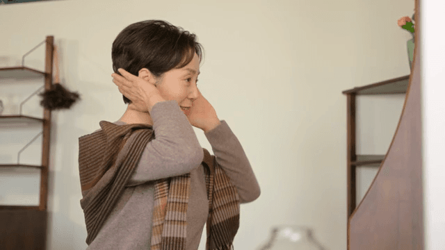 실내에서 거울을 보는 여성