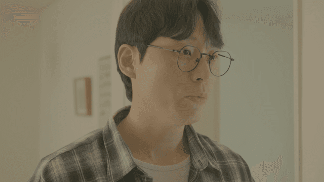 안경을 쓰고 체크 셔츠를 입고 말하는 남자