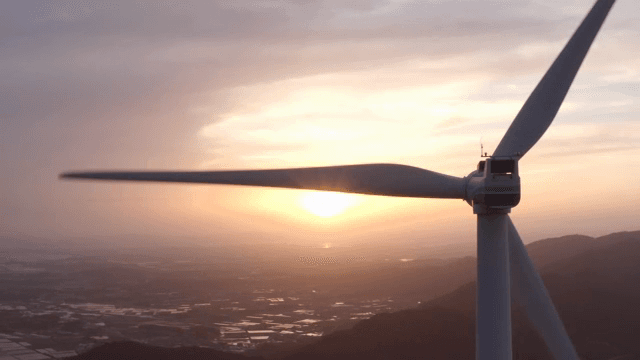 Wind turbines in a mountainous area with the setting sun