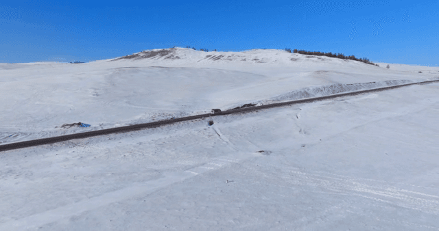 Snowy landscape with a road and vehicle