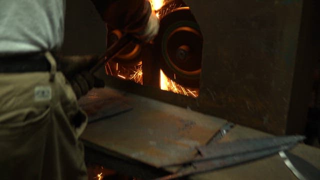 Metal being sharpened with sparks flying