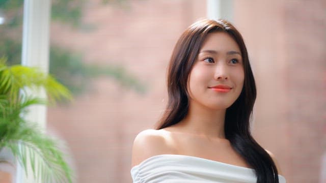 창문으로 햇빛이 들어오는 방에서 활짝 미소짓는 여성의 얼굴