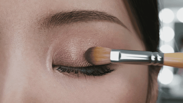 Woman applying eyeshadow with brush