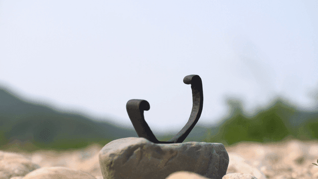 Wooden sculpture on a stone in nature