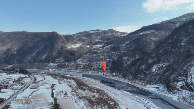 Paraglider over snowy mountain landscape