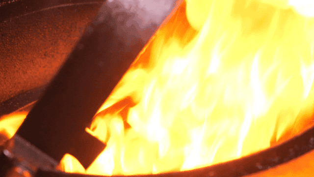 Meat cooked on grill rotating over flames