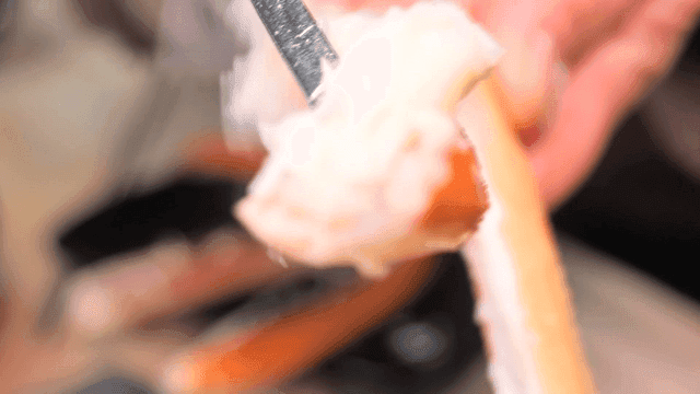 숟가락으로 게살을 발라내는 모습