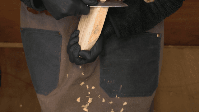 Woodcraft artisan carving wood with a knife