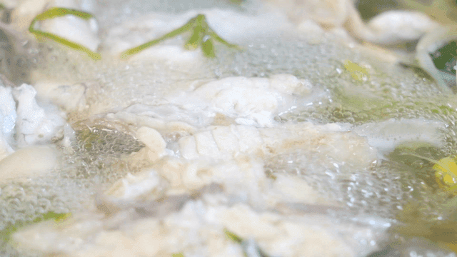 Clear pufferfish soup boiling with vegetables