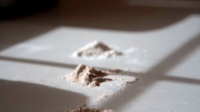 햇살이 비치는 실내 테이블 위의 다양한 종류의 밀가루 더미