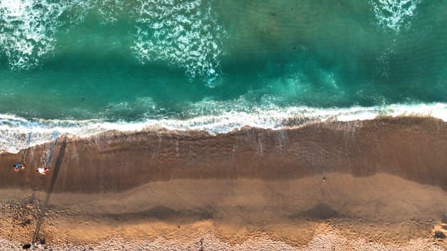 Aerial view of a serene beach with waves