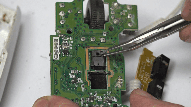 Repairing mouse circuit board components with tweezers