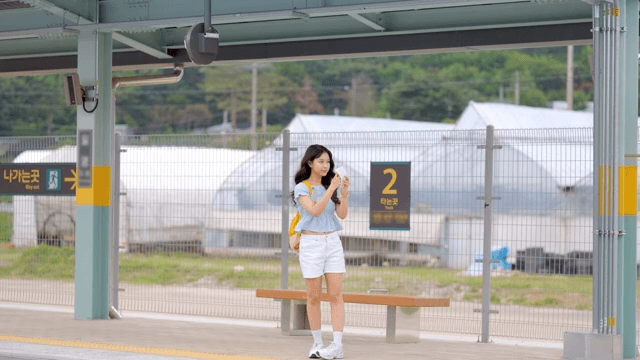 기차역의 젊은 여성과 들어오는 기차