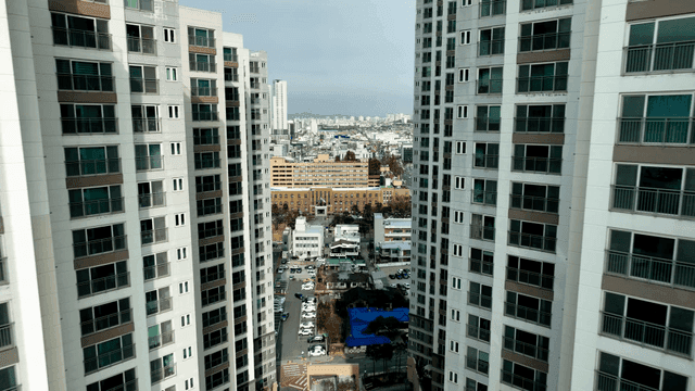 Cityscape visible between tall buildings.