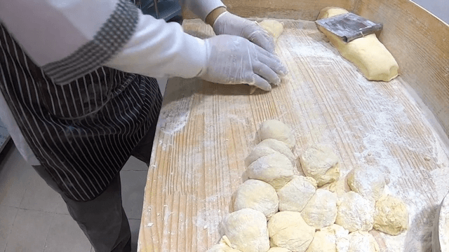 밀가루를 뿌린 표면에서 반죽을 하는 손