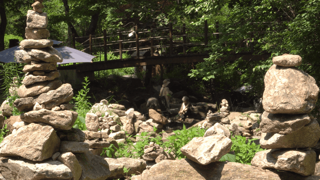 사람들이 있는 계곡 주변에 쌓인 돌탑