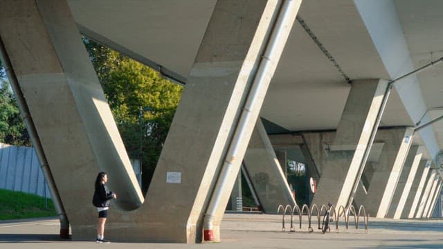 Woman stretching under a bridge outdoors