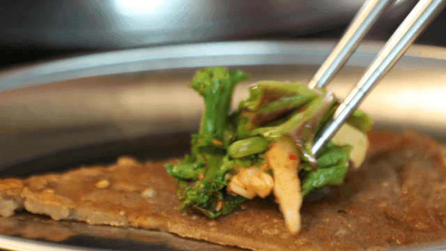 Buckwheat pancake topped with seasoned vegetables on plate