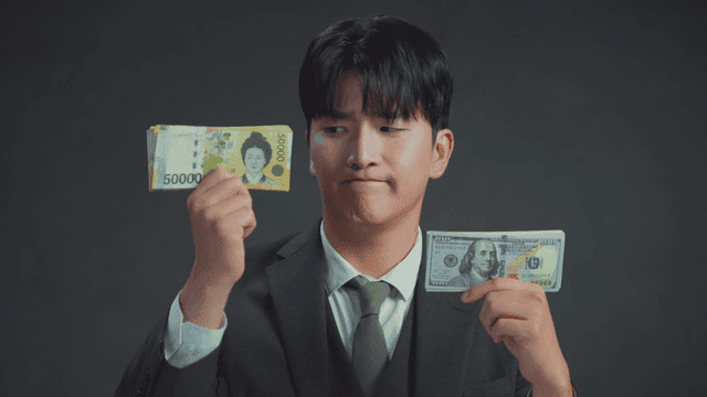 손에 든 미국 달러를 보고 미소짓는 남자