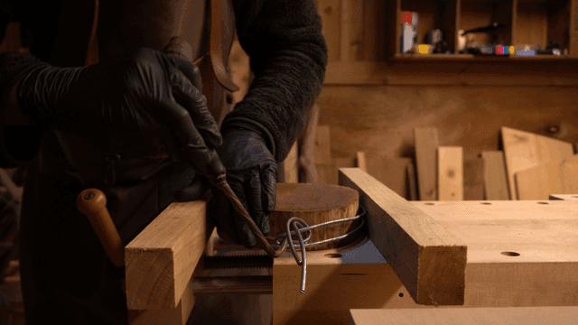 작업장에서 목재에 와이어를 감는 목공