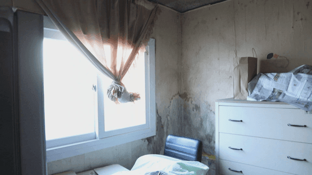 곰팡이 핀 창문과 커튼이 있는 어두운 방