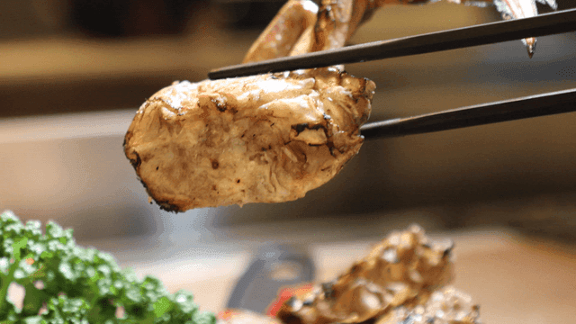 Grilled crab picked up with chopsticks