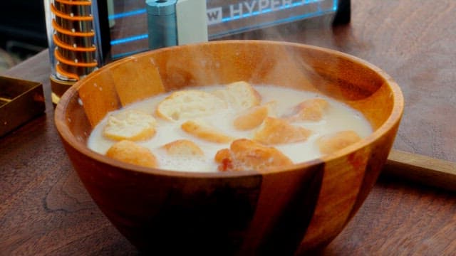 Freshly made soup with bread chunks in a wooden bowl on the table.