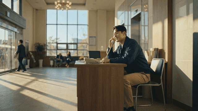 Male security guard on phone at reception desk