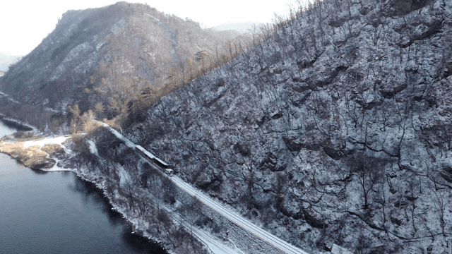 Train running through snow-covered mountain terrain
