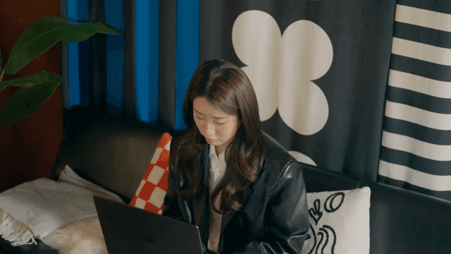 Woman lost in deep thought while working on her laptop