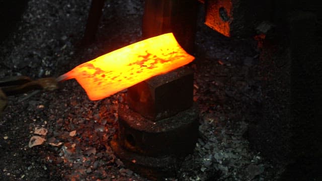 Red-hot metal being forged in a factory