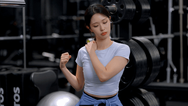 헬스장에서 어깨를 돌리며 부상 확인하는 젊은 여성