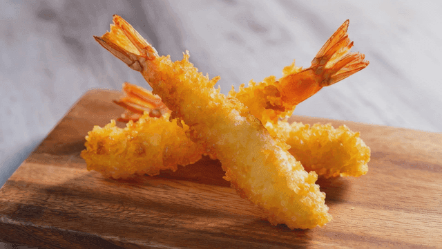 Crispy shrimp tempura on wooden cutting board