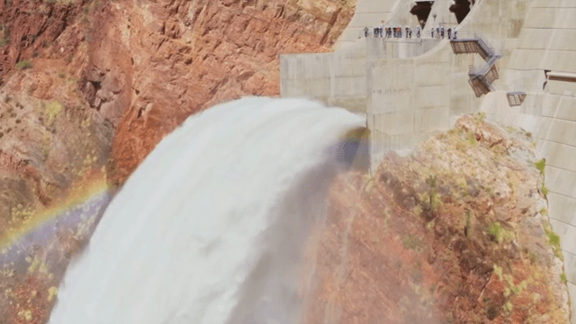 무지개가 있는 댐 위로 흐르는 물