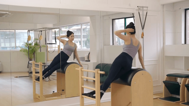 Woman exercising on a pilates barrel