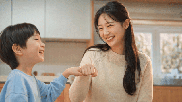 Woman and child smiling and giving fist bump at home