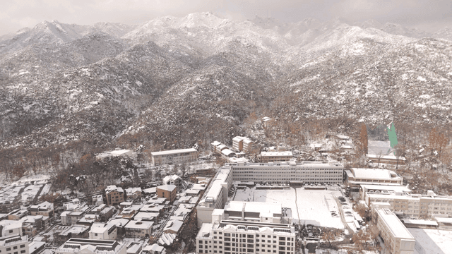 Snow-covered city with mountain backdrop