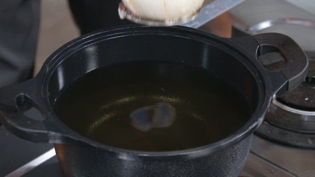 Deep Frying a Flour-covered Onion in Hot Oil