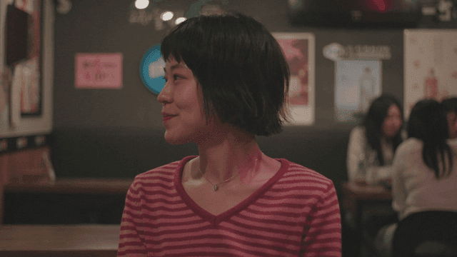 술집에서 줄무늬 티셔츠를 입고 웃는 여성