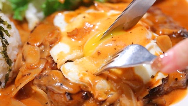 Cutting into a juicy hamburger steak