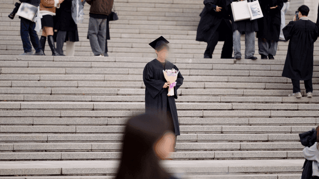 Graduate holding flowers on steps