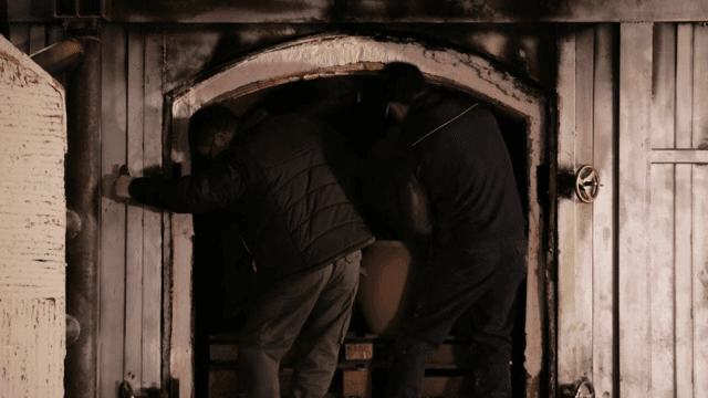 두 사람이 가마에 도자기를 넣는 모습