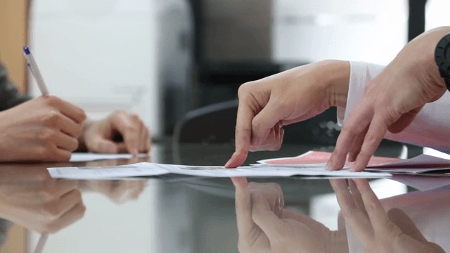 테이블 위에서 문서를 논의하는 손