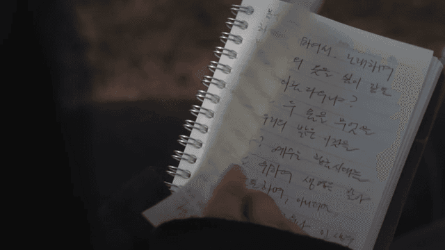 손으로 쓴 노트를 읽는 사람