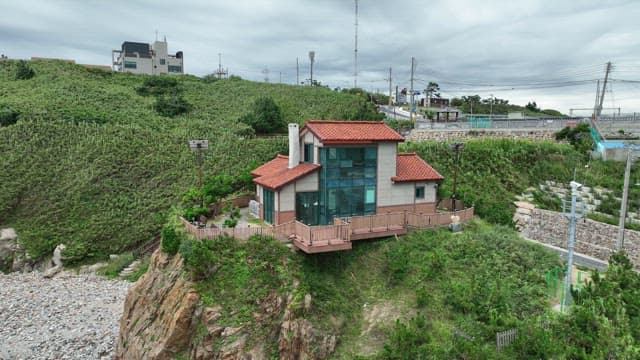 고요한 바다 근처의 빨간 지붕 집