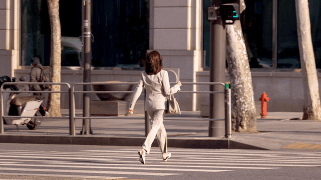 Woman in suit crossing crosswalk