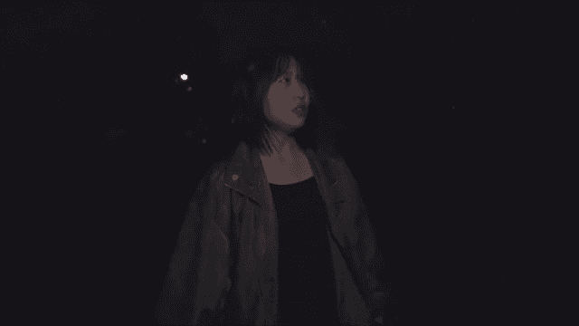 어두운 거리를 수색하는 여성